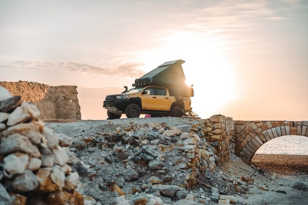 Toyota Hilux with an Alu-Cab rooftop tent at sunset