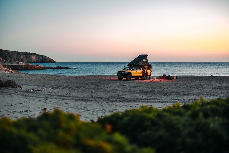 Camping on the beach at dusk with an Alu-Cab rooftop tent